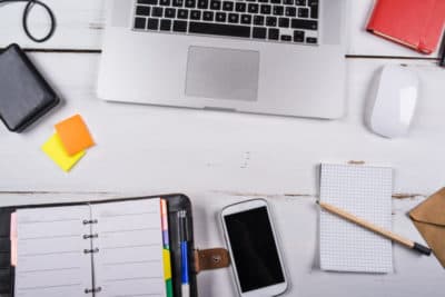 Escritorio con portátil, móvil, agenda y cuaderno